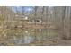 A serene pond is set on this property with a house and detached garage in the background offering natural beauty at 81 Bowers Rd, Moreland, GA 30259