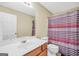 Bright bathroom featuring sink, toilet, and shower with a striped curtain at 1233 Kern Cv, Mcdonough, GA 30253