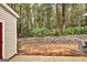 Backyard area featuring a retaining wall, trees, and fence at 3802 Austin Park Ln, Decatur, GA 30032