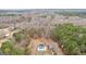 Expansive aerial shot showcasing a private estate with a sparkling pool, lush landscaping, and surrounding wooded area at 203 Shelby Ln, Fayetteville, GA 30215