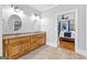 Bathroom features a double sink vanity with wood cabinets and decorative mirrors, creating a stylish space at 203 Shelby Ln, Fayetteville, GA 30215