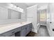 Bathroom showcasing a vanity with a gray cabinet, and a bright shower space featuring an open entry at 203 Shelby Ln, Fayetteville, GA 30215