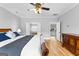 Bright bedroom featuring hardwood floors, ensuite bathroom and decorative ceiling fan at 203 Shelby Ln, Fayetteville, GA 30215