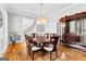 Elegant dining room with a round table, chandelier, hardwood floors, and a decorative cabinet at 203 Shelby Ln, Fayetteville, GA 30215