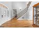 Inviting foyer featuring hardwood floors, a curved staircase, and a decorative arched front door at 203 Shelby Ln, Fayetteville, GA 30215