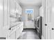 Bright laundry room with white cabinetry, utility sink, and modern washer and dryer at 203 Shelby Ln, Fayetteville, GA 30215