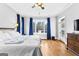 Bright main bedroom features hardwood floors, white walls, and a window with blue curtains at 203 Shelby Ln, Fayetteville, GA 30215