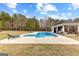 Beautiful in-ground pool and cabana with lounge chairs, set against a backdrop of lush trees at 203 Shelby Ln, Fayetteville, GA 30215