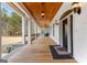 Long covered porch with outdoor lighting fixtures, wood ceilings, and black railings at 203 Shelby Ln, Fayetteville, GA 30215