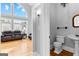 Charming powder room with a pedestal sink, decorative mirror, and hardwood floors at 203 Shelby Ln, Fayetteville, GA 30215