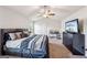 Comfortable bedroom with tray ceiling, ceiling fan, and dark furniture at 316 Denton Way, Hampton, GA 30228