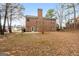 Spacious red brick two-story home featuring a large backyard and classic chimney at 306 Interlake Pass, Mcdonough, GA 30252