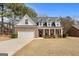 Charming two-story brick home with a two-car garage and a well-manicured lawn at 306 Interlake Pass, Mcdonough, GA 30252