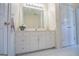 Bathroom showcasing a vanity with white cabinets, a large mirror, and double doors to a closet at 111 Dixson Rd, Bowdon, GA 30108