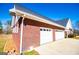 Side view of brick home, highlighting the attached two-car garage with white doors at 111 Dixson Rd, Bowdon, GA 30108