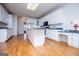 Bright kitchen featuring an island with black appliances and hardwood floors at 111 Dixson Rd, Bowdon, GA 30108