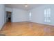 Inviting living room with hardwood floors, large windows, and an open doorway to another room at 111 Dixson Rd, Bowdon, GA 30108