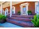 Welcoming brick porch with stairs adorned with potted plants leading to the decorative front door at 111 Dixson Rd, Bowdon, GA 30108