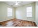This bedroom features two windows allowing ample natural light, a ceiling fan and wood floors at 12 Paces Lakes Overlook, Dallas, GA 30157