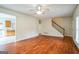 Bright living room with hardwood floors, a staircase and a view into the kitchen at 12 Paces Lakes Overlook, Dallas, GA 30157