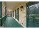 Inviting covered porch with painted wood flooring, classic lantern lighting, and a view of the front yard at 12 Paces Lakes Overlook, Dallas, GA 30157