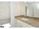 Bathroom vanity features stone countertop, white cabinets, and large mirror at 4604 Mossey Dr, Stonecrest, GA 30038