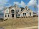 Beautiful two-story home with light brick and elegant architectural design, set against a clear blue sky at 4604 Mossey Dr, Stonecrest, GA 30038
