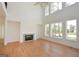 Sunlit living room boasts soaring ceilings, fireplace, and large windows overlooking the backyard at 4604 Mossey Dr, Stonecrest, GA 30038