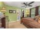A bedroom with green walls, ceiling fan, and a bathroom visible in the doorway at 4770 Shiloh Springs Rd, Cumming, GA 30040
