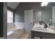 Bright bathroom featuring tile floors, a white sink with large mirror, and a built-in tub at 1632 Zacharys Way, Mcdonough, GA 30253