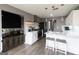 Modern kitchen with white cabinets, stainless steel appliances, and gray plank flooring at 1632 Zacharys Way, Mcdonough, GA 30253