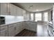 Bright kitchen with white cabinets, modern lighting, quartz countertops, and stainless appliances at 1632 Zacharys Way, Mcdonough, GA 30253