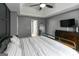 This main bedroom features gray walls, a bed with striped linens, and wood-look flooring at 1632 Zacharys Way, Mcdonough, GA 30253