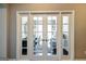 Elegant french doors open to reveal home office with stylish desk, chair, and abundant natural light at 2446 Naples St, Hoschton, GA 30548