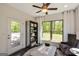 Relaxing sunroom with large windows, backyard views, cozy seating, and access to outdoor patio at 2446 Naples St, Hoschton, GA 30548