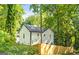Bright white home with black trim surrounded by mature trees and a newly stained wood fence at 200 Adeline Nw Ave, Atlanta, GA 30314