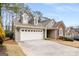 Charming home featuring a two-car garage, a mix of stucco and brick, and dormer windows on a neatly manicured lawn at 103 Augusta Dr, Peachtree City, GA 30269