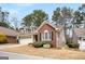 This home features a two-car garage, brick accents, dormer windows, and lush landscaping in a tranquil neighborhood setting at 103 Augusta Dr, Peachtree City, GA 30269