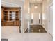 A home foyer with a view into a carpeted office with built-in shelving, and a decorative light fixture hanging from the ceiling at 103 Augusta Dr, Peachtree City, GA 30269