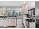 Bright kitchen featuring white cabinets, hardwood floors, and stainless steel appliances at 103 Augusta Dr, Peachtree City, GA 30269