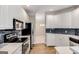 Modern kitchen with white cabinetry, hardwood floors, and stainless steel appliances at 103 Augusta Dr, Peachtree City, GA 30269