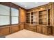 Office featuring custom wood built-in shelving, drawers, cabinets, a plush carpet, and bright natural light at 103 Augusta Dr, Peachtree City, GA 30269