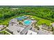 Aerial view of a community featuring a pool, tennis courts, clubhouse, and wooded surroundings at 208 Cottonwood Cir, Peachtree City, GA 30269