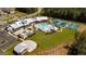 Aerial view showcases a community with a clubhouse, pool, tennis courts, and parking at 208 Cottonwood Cir, Peachtree City, GA 30269