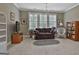 Comfortable bedroom with a love seat, neutral walls, a chandelier and three windows at 208 Cottonwood Cir, Peachtree City, GA 30269