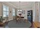 Cozy dining room with wood table, four chairs, large window, dark wood flooring, and a gray and white braided rug at 208 Cottonwood Cir, Peachtree City, GA 30269