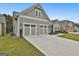 Side view featuring a long driveway leading to a three-car garage, complemented by a green lawn at 208 Cottonwood Cir, Peachtree City, GA 30269