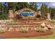 Stone sign for Cresswind community, beautifully landscaped with colorful flowers and greenery at 208 Cottonwood Cir, Peachtree City, GA 30269