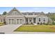 Charming home featuring a spacious three-car garage, manicured lawn, and inviting covered entry way at 208 Cottonwood Cir, Peachtree City, GA 30269
