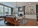 Inviting living room with built-in bookshelves surrounding fireplace, large windows and dark wood flooring at 208 Cottonwood Cir, Peachtree City, GA 30269